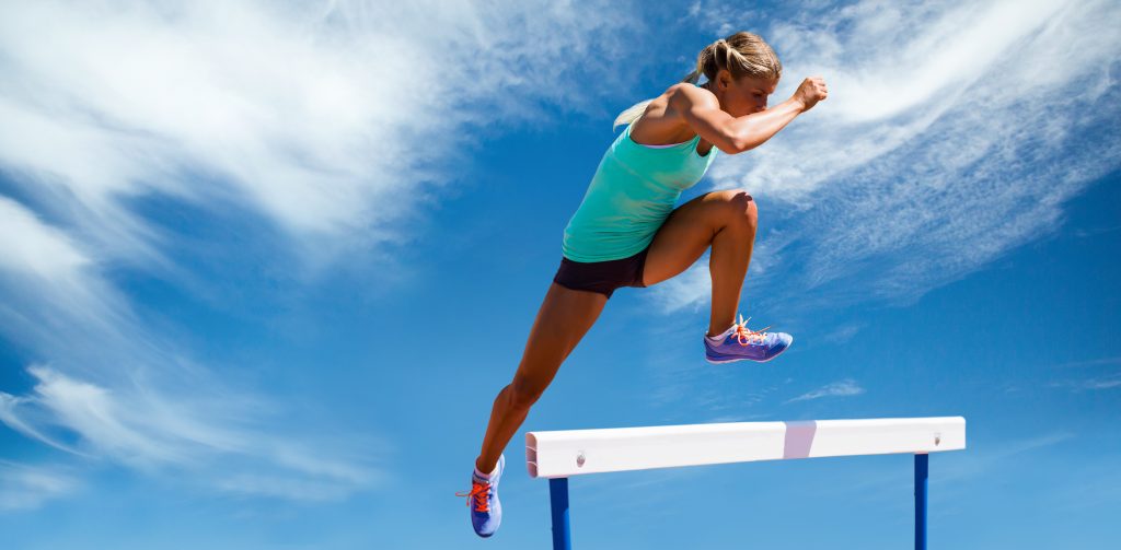 אישה קופצת מעל מוט כדימוי למוטיבציה באימונים